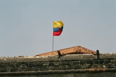 Colorful Colombian flag waving at a historic fort in sunny Cartagena, Colombia.