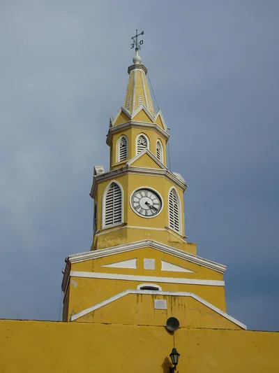 Discover the historic Torre del Reloj in Cartagena, an iconic landmark with its vibrant yellow facade.