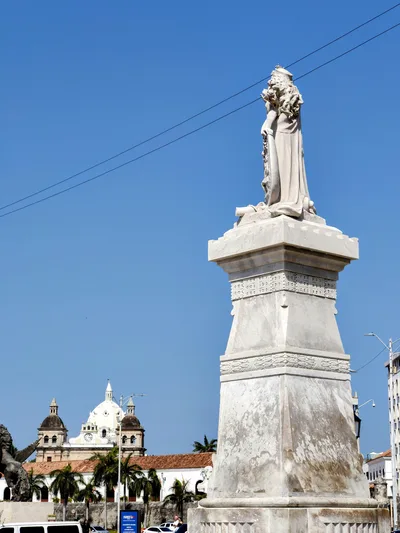 A landmark statue with a historic church in the background, Cartagena, Colombia.