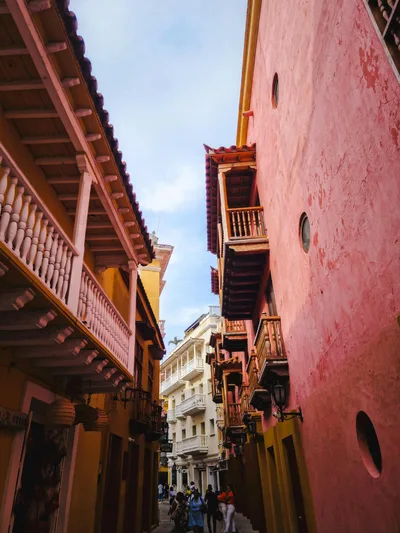 Colorful narrow street with balconies in Cartagena, Colombia, highlighting vibrant architecture.