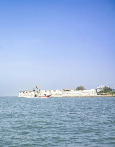 Beautiful sea view of a historic fortress on the Cartagena coastline under clear blue skies.