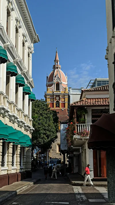 Charming view of a historic street in Cartagena, Colombia featuring a colorful bell tower.